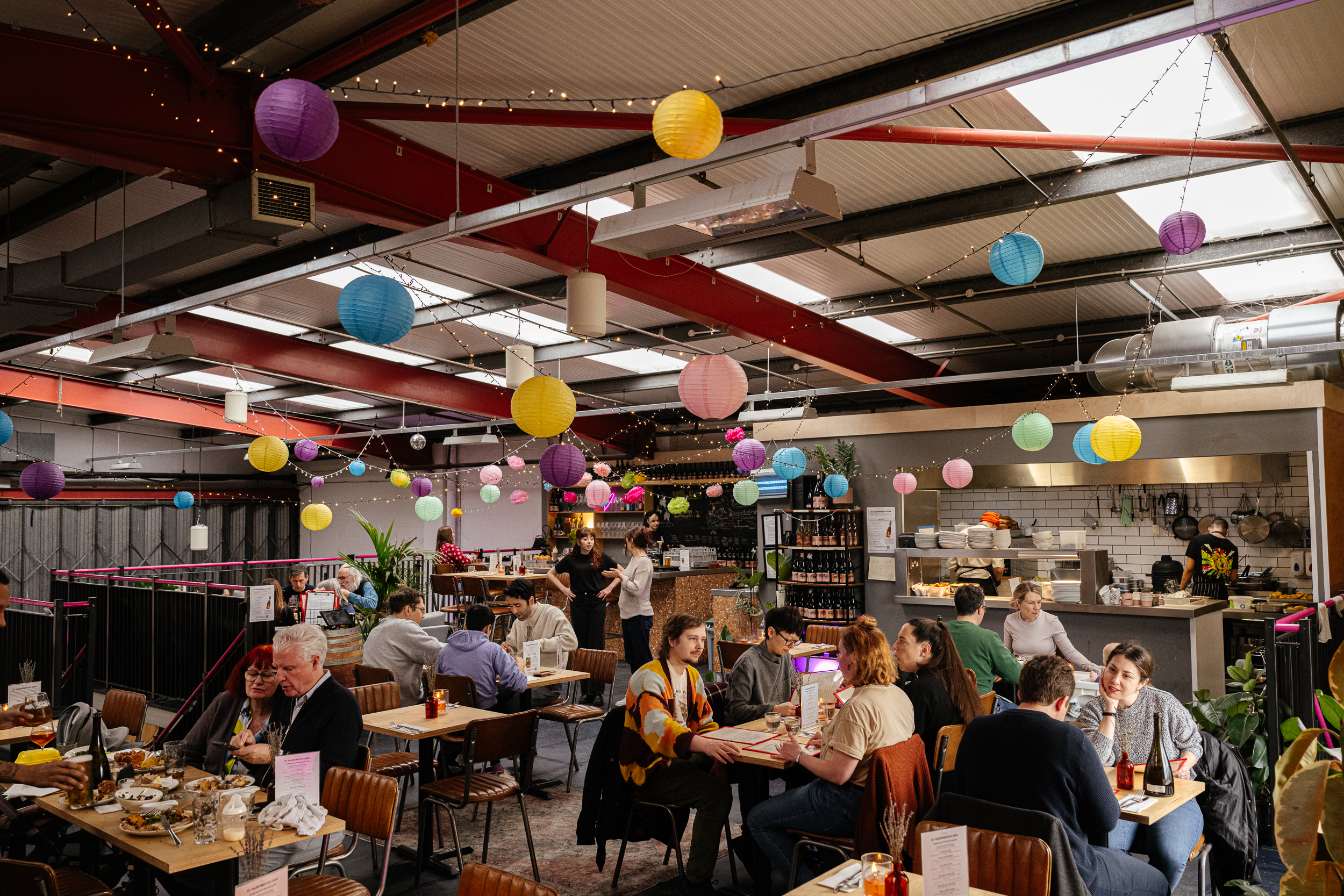 Interior image of Renegade Urban Brewery, including tables, chairs, streamers and low beams.