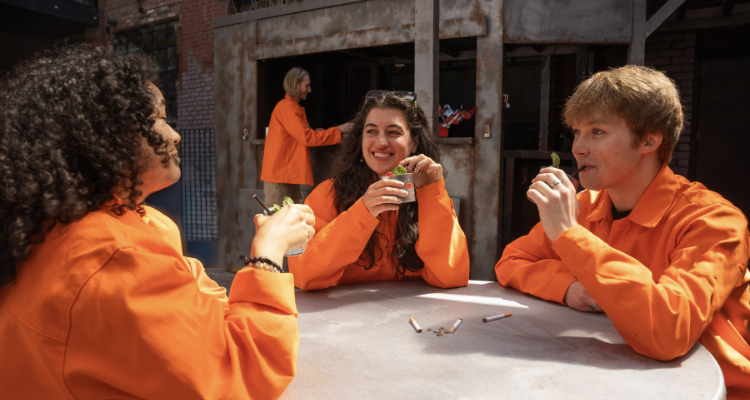 People drinking outdoors in orange jumpsuits at Alcotraz - The Yard.