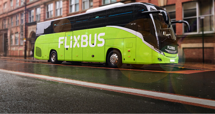 A Big Green Flixbus Coach Driving On A Road.
