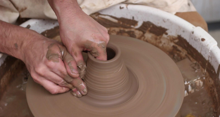 Someone using a pottery wheel at Seven Limes Manchester.