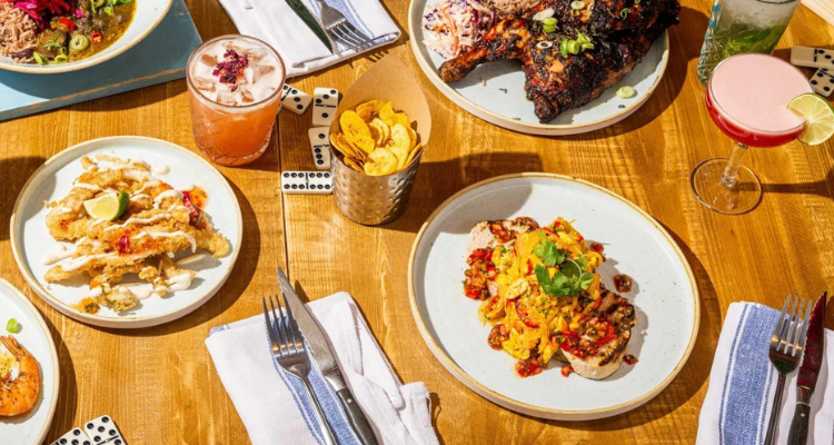 Turtle Bay bottomless brunch flat lay with food and dominoes.