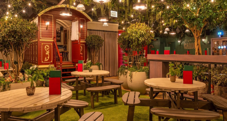Flight Club Wales' stunning rooftop terrace, fronting foliage, hanging lights and a cute cabin you can hire.