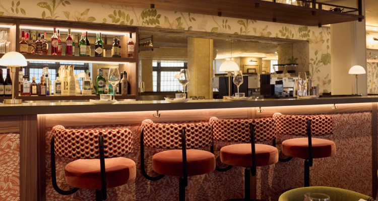 A picture of Liberty Carnaby Street’s bar area, featuring four oxblood-coloured patterned wooden stools.