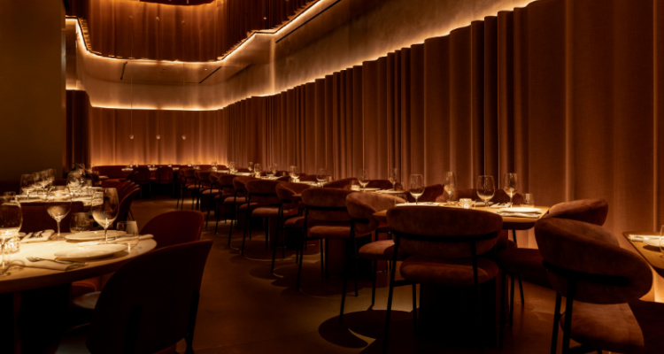 Interiors of Mr Porter Mayfair, including velvet curtains and rounded booths.