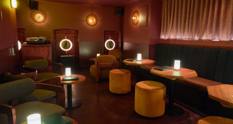 Downstairs at Little Fires Bethnal Green, with velvet seats, a DJ area and moody dim lighting.