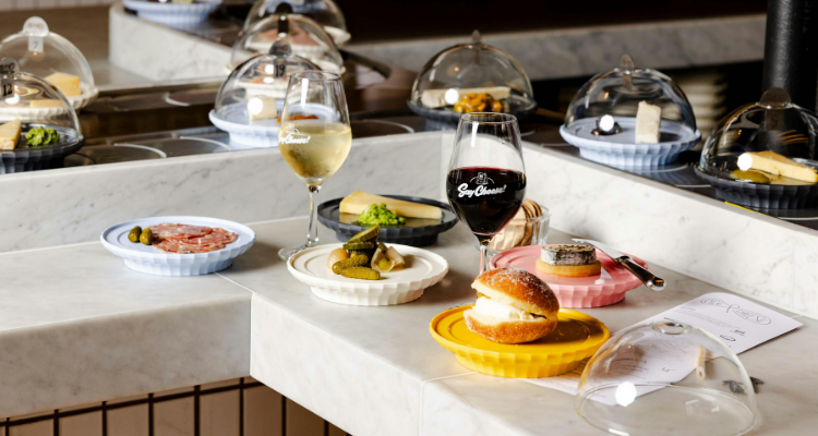 A selection of plates at Pick & cheese, next to a glass of red and white wine.