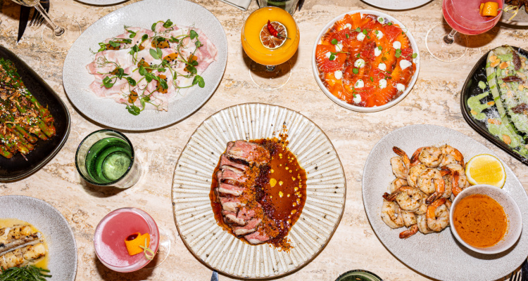 Milk Beach Soho tablescape showing dishes on their feast menu, including ribeye in oyster and tarragon butter alongside a prawn dish.