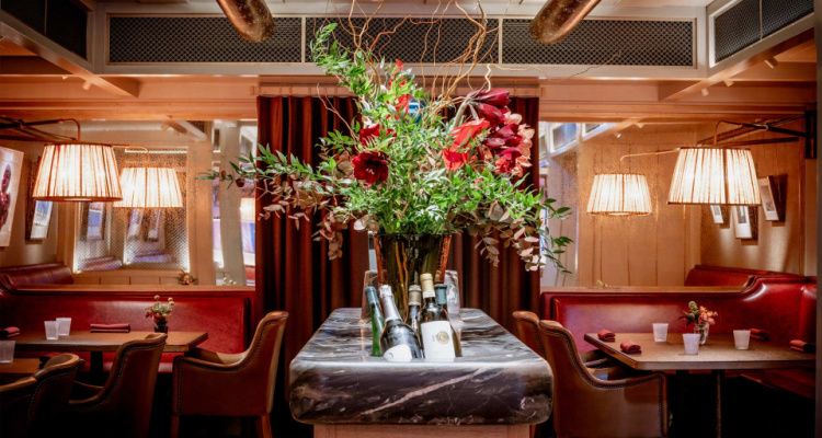 Interiors of The Cocochine Mayfair's dining room, including leather seating, lava middle table and flowers.