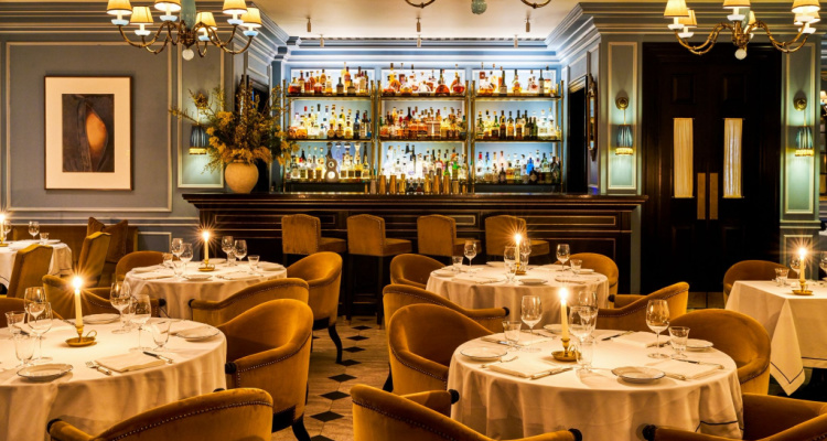 Interiors of The Twenty Twenty Two, including tables with white tablecloths and golden accents.