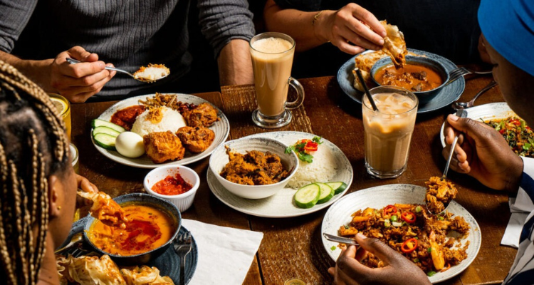 People sharing food at Roti King.