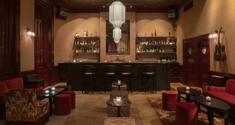 A picture of The Good Oak Notting Hill's elegant interiors, fronting red wine and cream colours paired with dark wood.