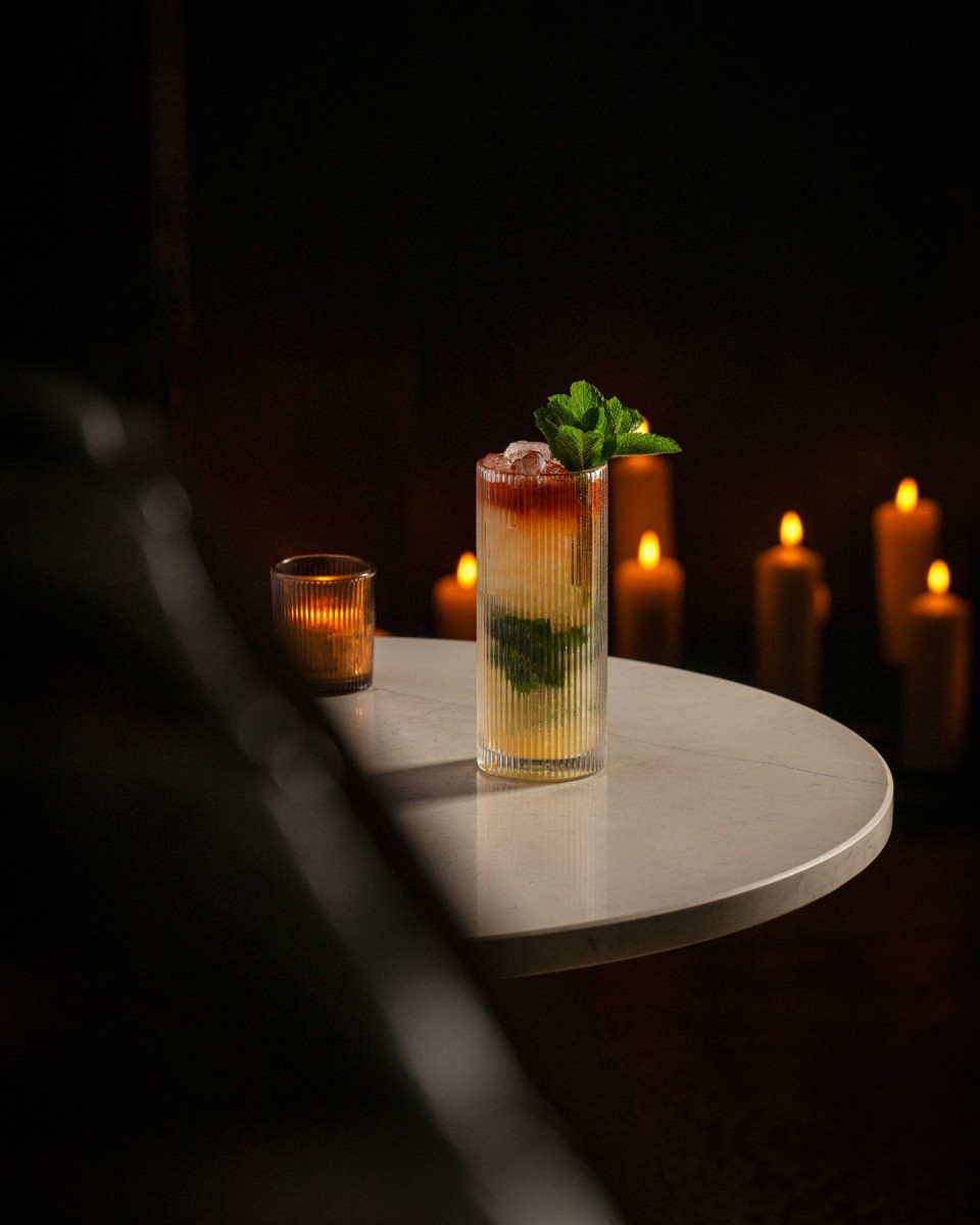 Best Cocktail Bars in Glasgow 2026: Where to Drink 12 A candlelit cocktail with fresh mint on a marble table inside Devil of Brooklyn in Glasgow