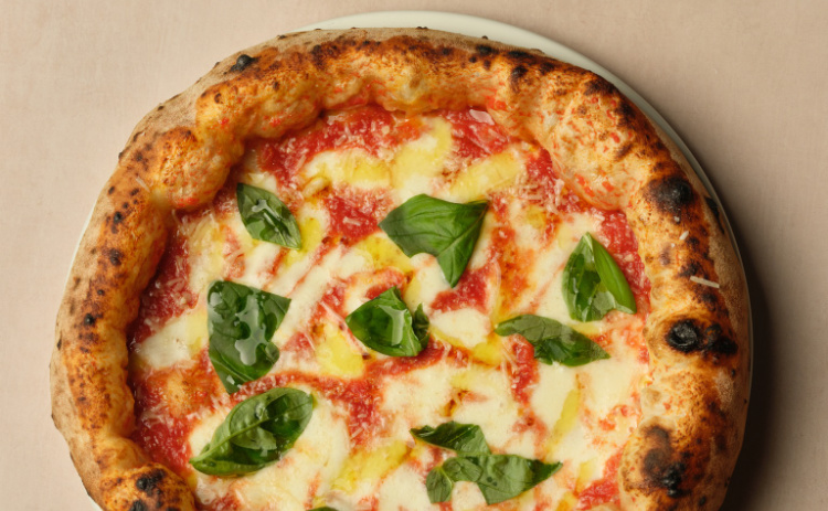 Margherita pizza from Napoli on the Road, featuring mozzarella, tomato and basil on pizza dough.