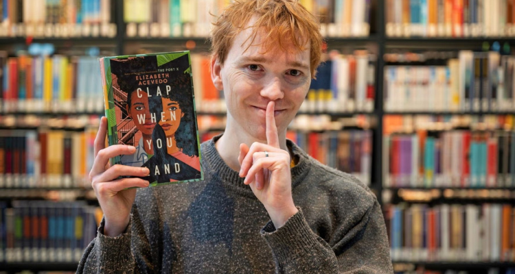 Man with booking making a sh sign. 