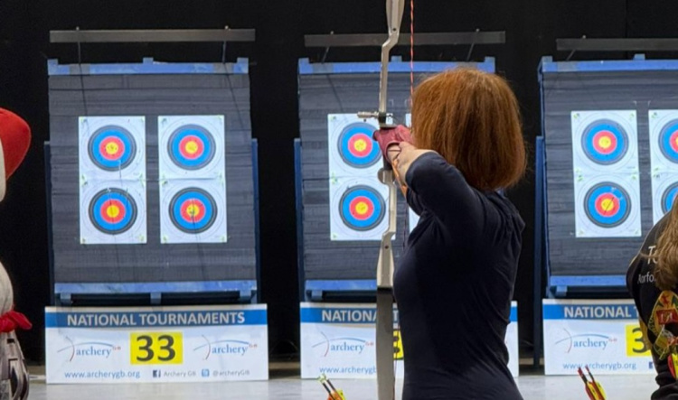 Woman practicing archery on a target at 2020 Archery in London.