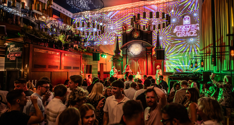 The interiors at Amazing Grace London Bridge, with a band performing on stage.