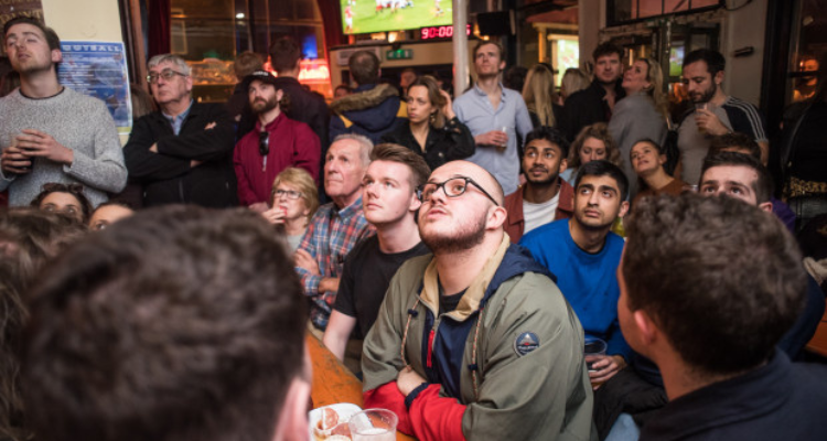 Fans watching sports in a pub.