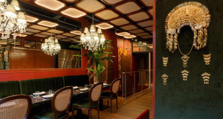 A picture of Le Nusa's stylish interiors, fronting giant chandeliers, red walls and historical artefacts.