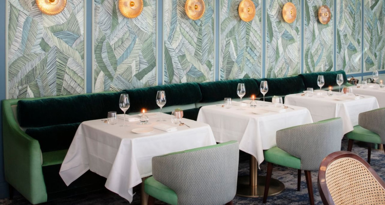 Interiors of Tom Brown at The Capital, featuring velvet booths and white tablecloths.