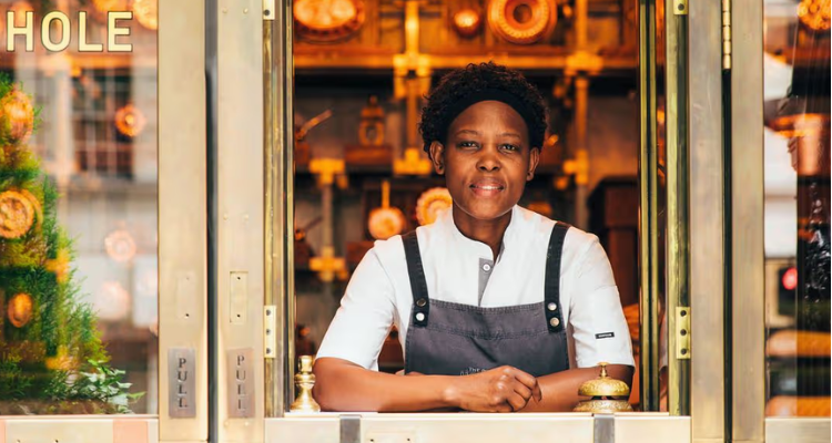 A chef in the window of the pie takeaway.