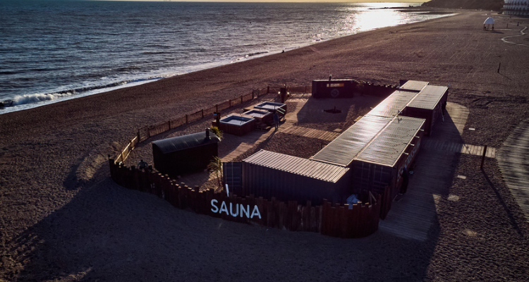 The exterior of a sauna venue built directly on a beach on the coast.