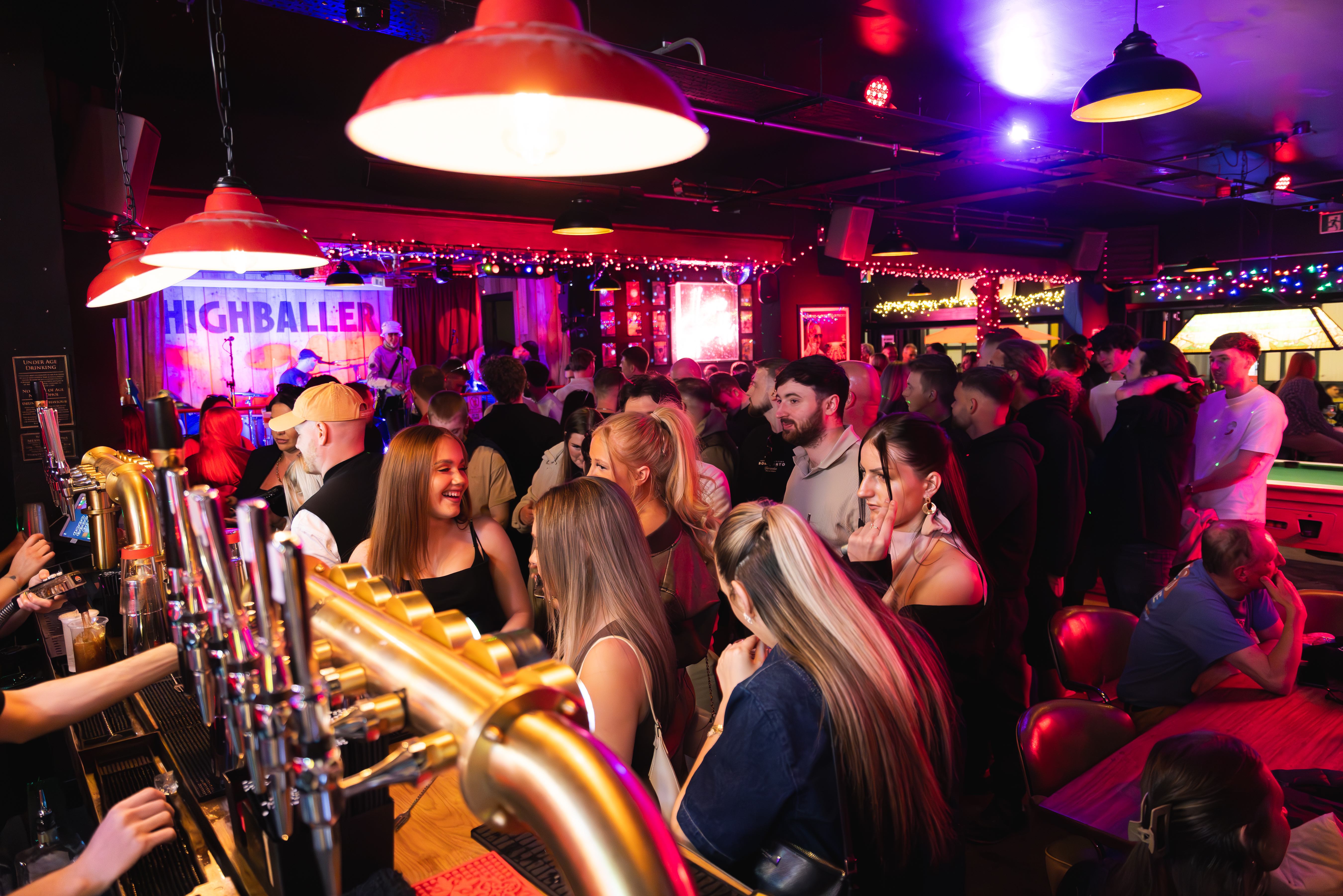 bar full of people with a stage in the background