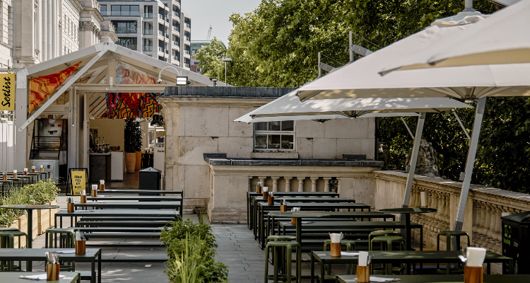 A terrace with umbrellas and benches.