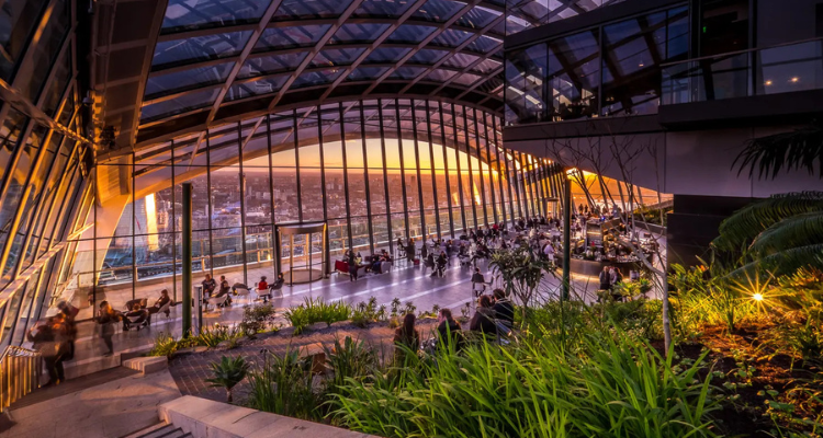 The sun rising at Sky Garden as people sit and watch.
