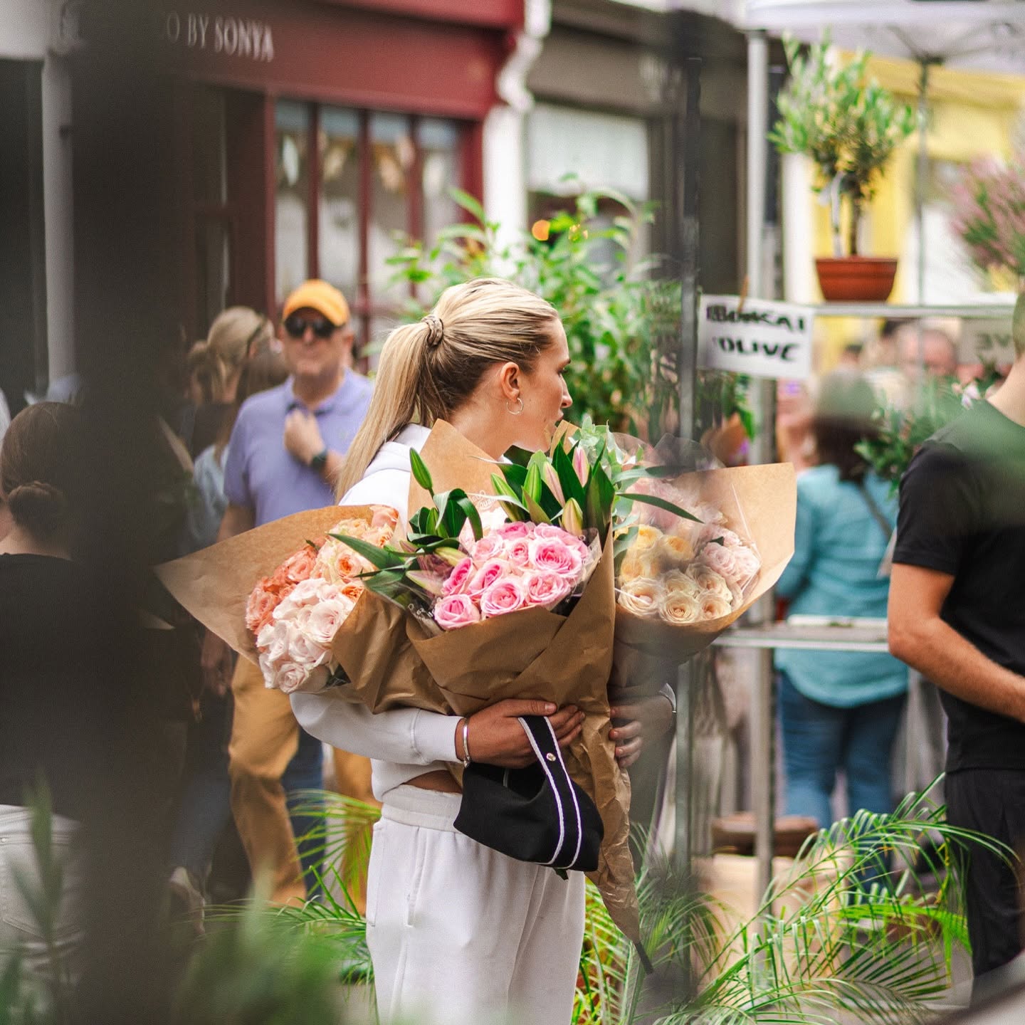 Woman holding bouquets of flowers at Columbia Road Flower Market.