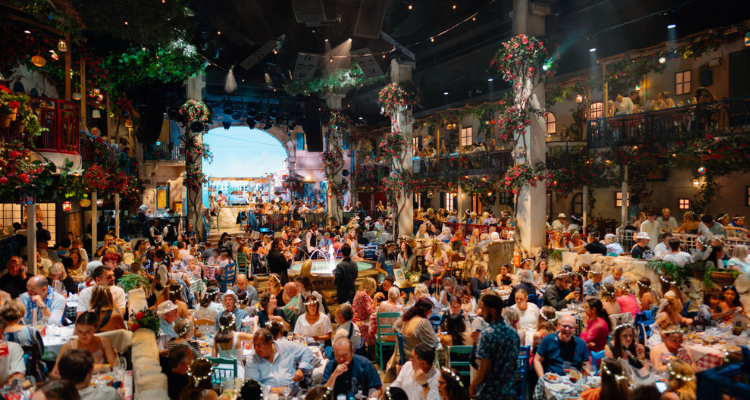 The set of Mamma Mia! The party as a massive crowd of diners eat in a Greek-styled taverna.