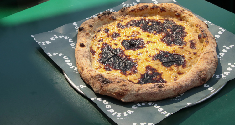 A pizza topped with creamy custard to resemble a pastel de nata. 