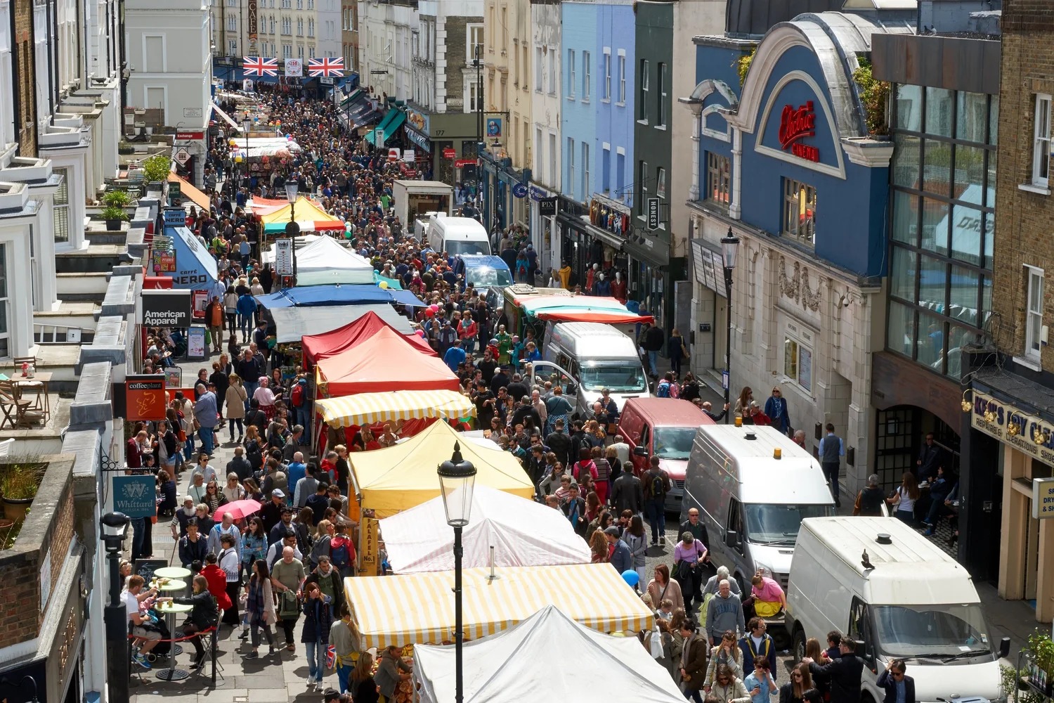 Busy crowds and stalls at Portobello Market in Notting Hill.