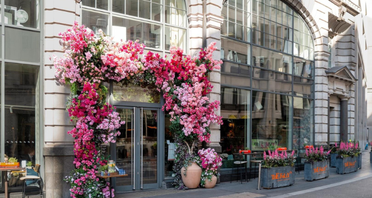 The exterior of a restaurant with the doorway covered in florals.