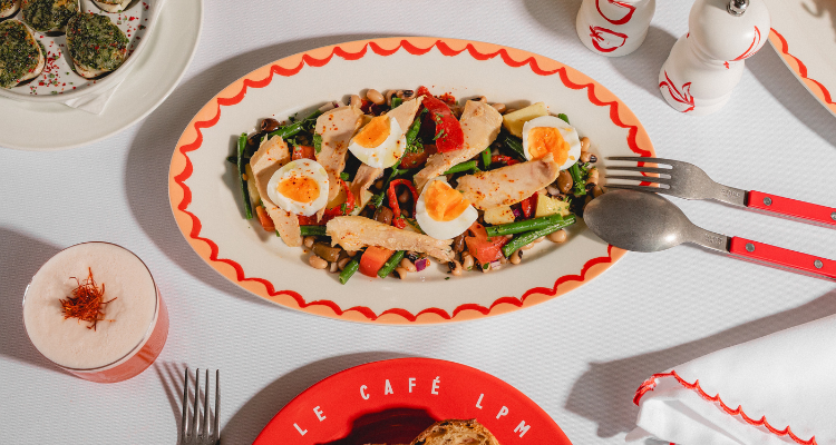 Le Cafe LMP menu image with a salad on a peach and red plate.