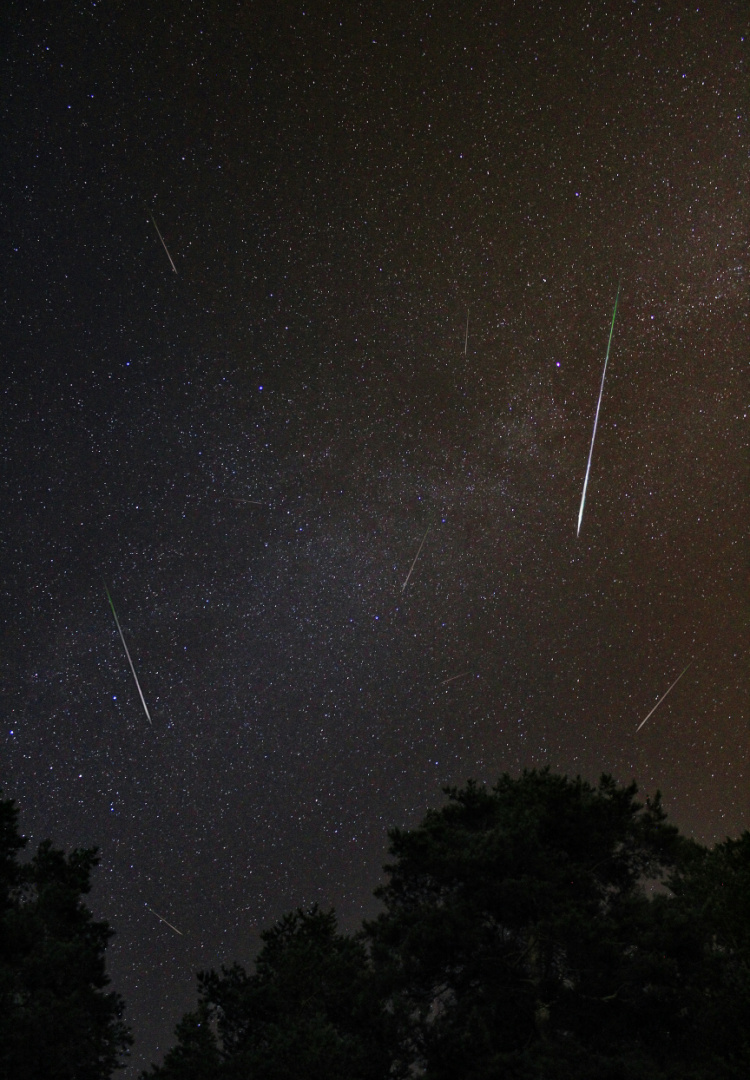 Meteors across the night sky in Russia as part of Perseid Meteor Shower.