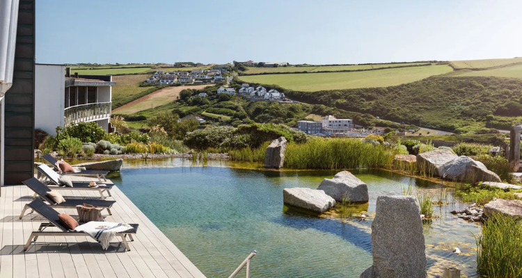 A natural outdoor pond-like pool with a view of the rolling countryside.