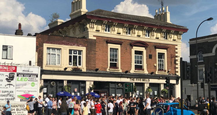 Crowd of people standing outside of a pub in South London.