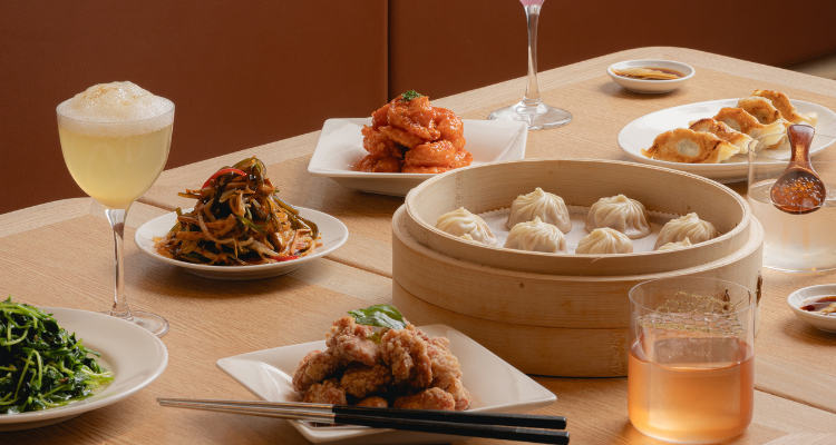 Din Tai Fung food on the table, with bao and crispy chicken.