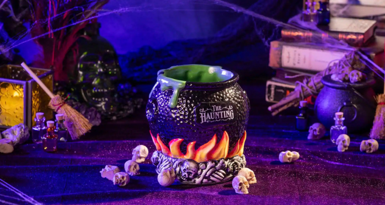 A spooky cocktail cup surrounded by Halloween decor.