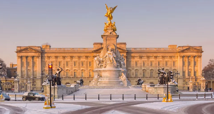 Buckingham Palace in the winter with some snow on the ground.
