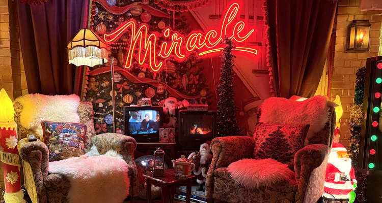 A kitsch Christmas-themed interior with a neon sign and holiday decor.