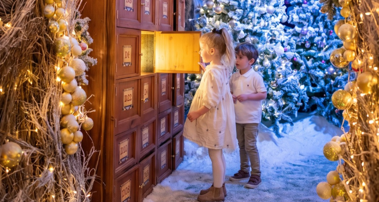 Children opening a drawer with light coming out, surrounded by snow.